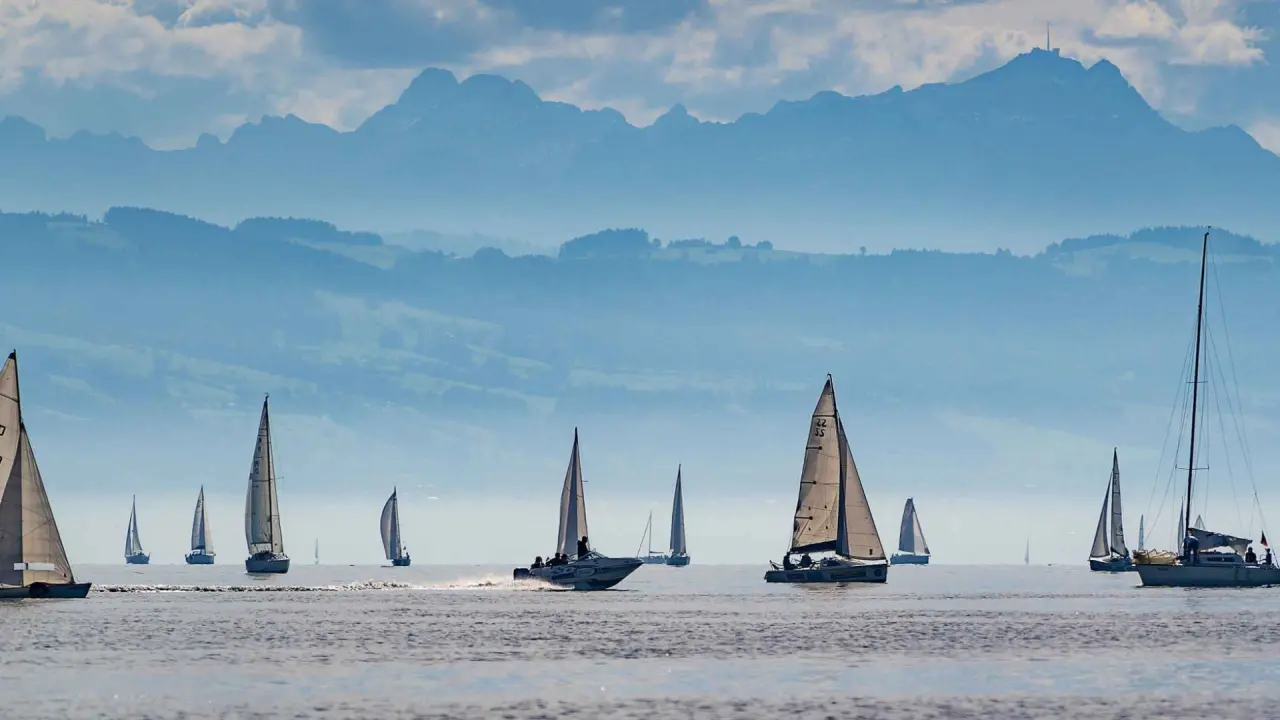 Malerische Segelboote auf dem See mit beeindruckendem Alpenpanorama im Hintergrund, eine entspannende Szenerie nahe Hotel Bayrischer Hof.
