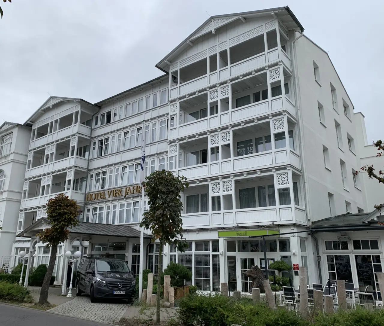 Aussenansicht des Hotel Vier Jahreszeiten Binz im Stil der Bäderarchitektur unter bewölktem Himmel.