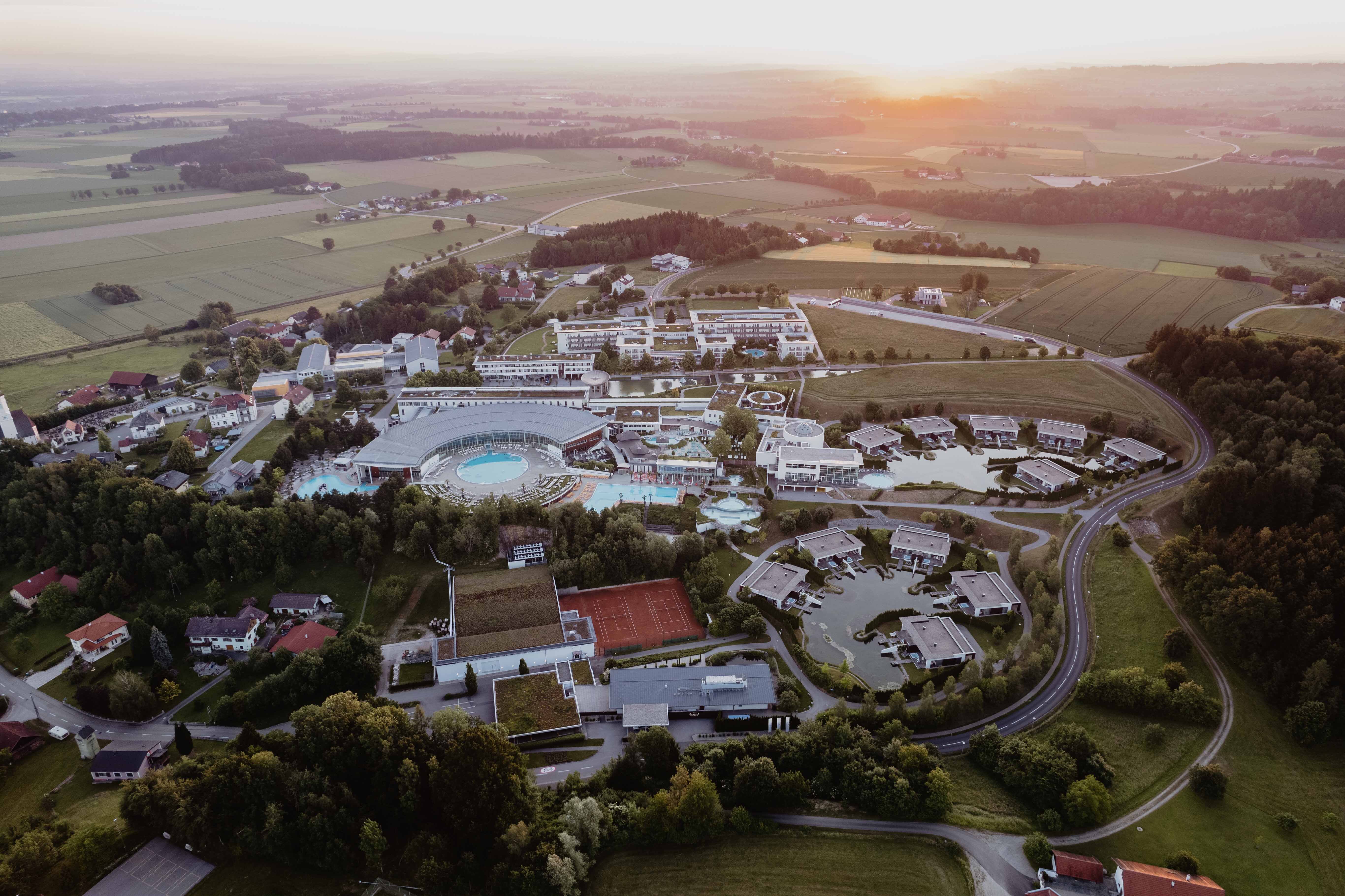 4*S Hotel Spa Resort Geinberg in Geinberg – Luftaufnahme des gesamten Resorts bei Sonnenuntergang | Wellnesshotel Innviertel