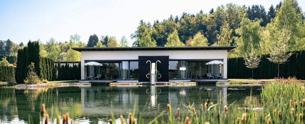 Modernes See-Chalet am Naturteich im 4*S Hotel Spa Resort Geinberg mit Terrasse und Liegen.