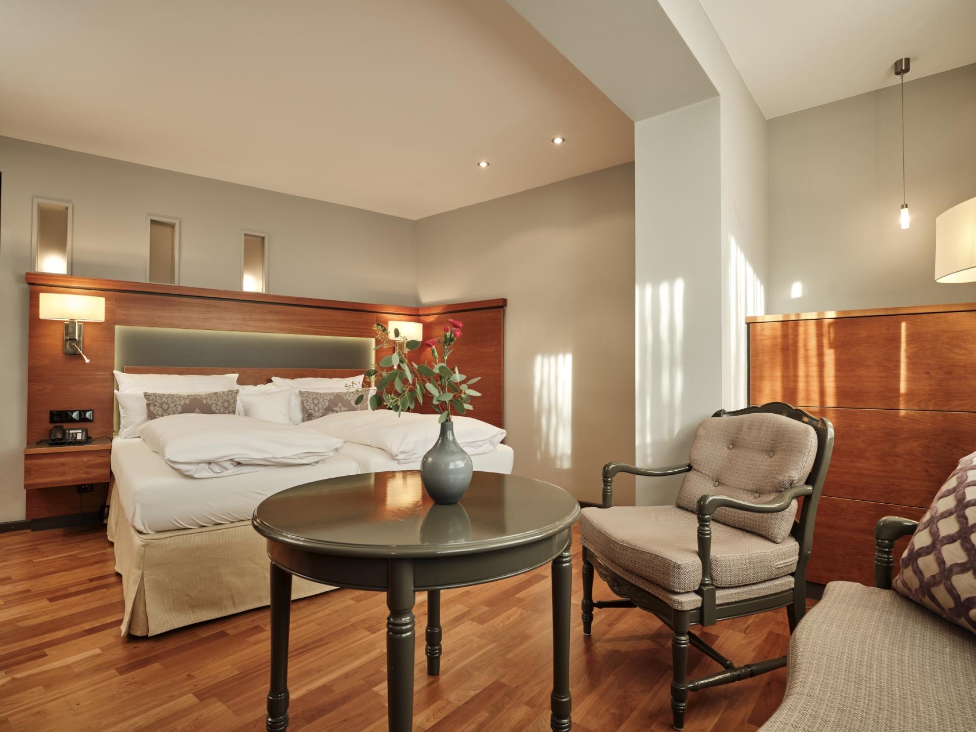 Ferien- und Wellnesshotel Reppert in Hinterzarten – Helles Hotelzimmer mit Doppelbett und Tisch | Wellnesshotel Schwarzwald