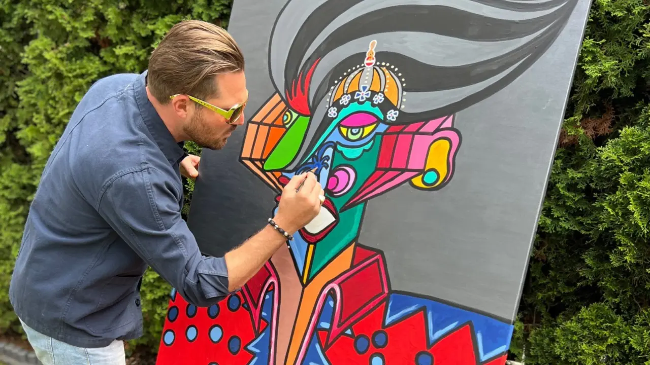 Künstler malt farbenfrohes, abstraktes Kunstwerk im Garten des Alpine Hideaway Zillertalerhof.