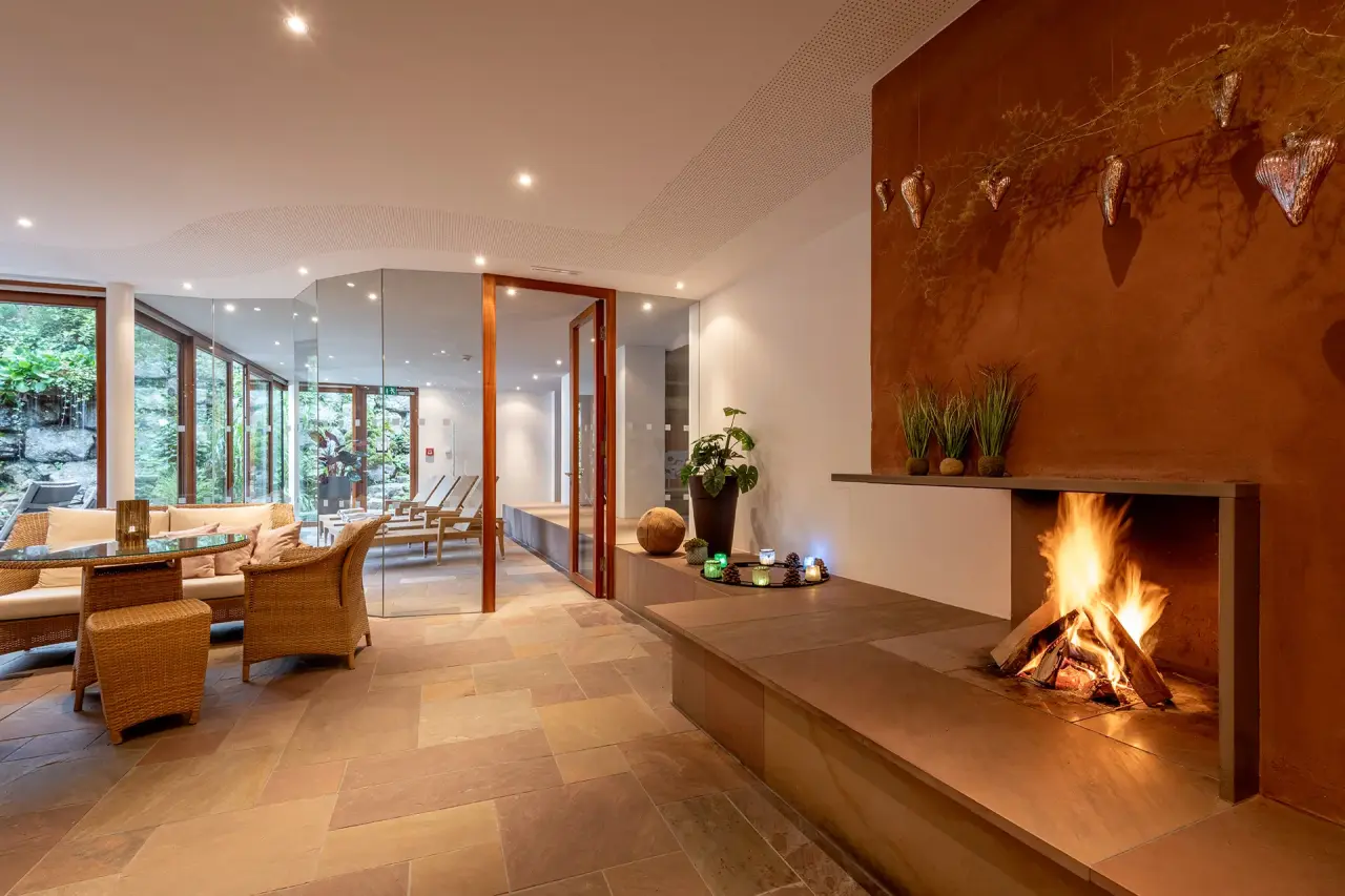 Gemütlicher Wellness-Loungebereich mit Kamin und Blick ins Grüne im Relax- & Vitalhotel Adler.