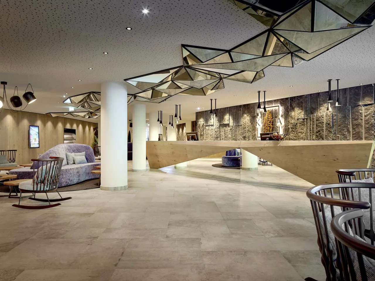 Moderne und einladende Hotellobby mit Rezeption und Sitzbereichen im Krumers Alpin – Your Mountain Oasis****s.