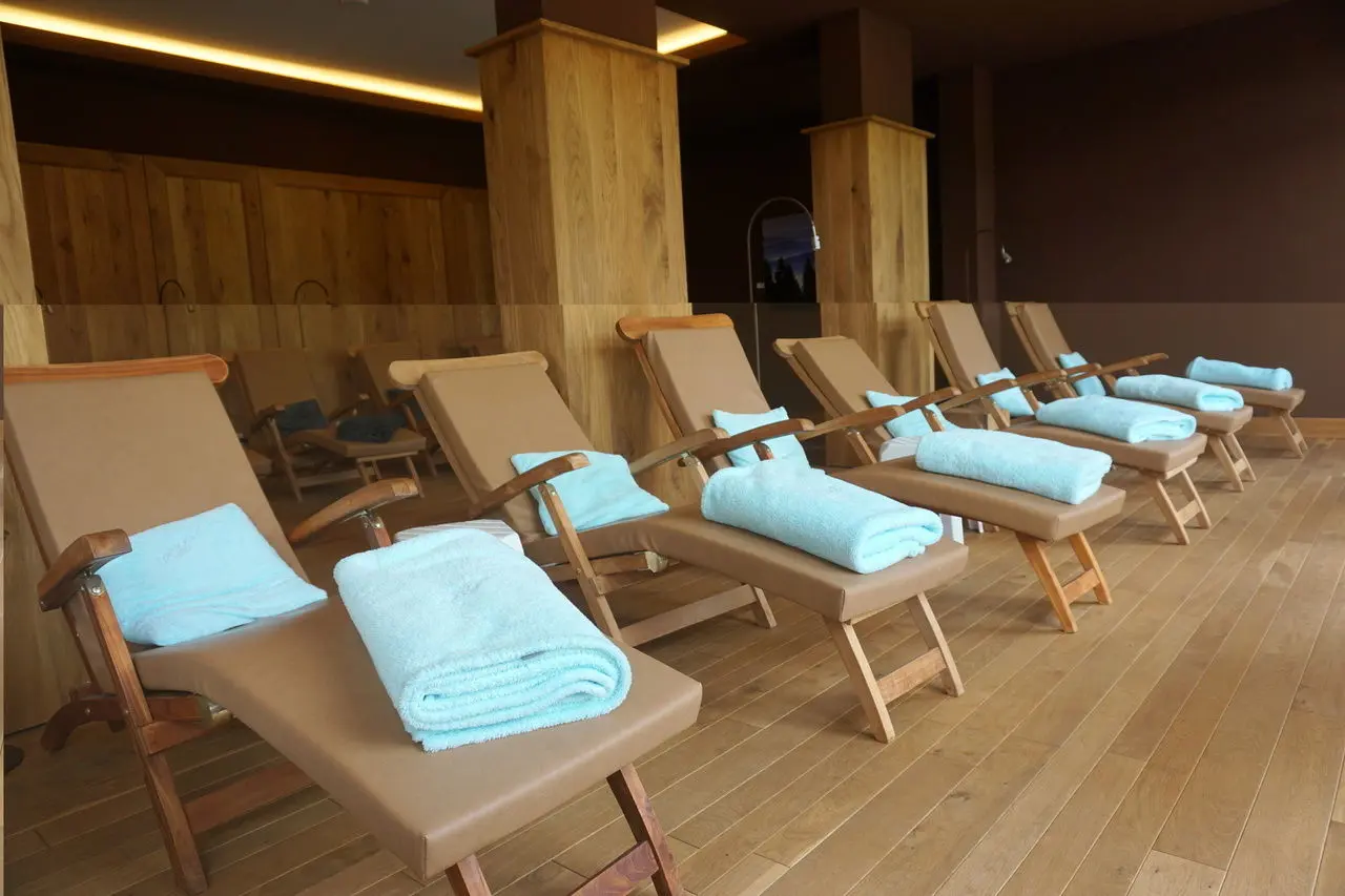 Entspannungsbereich mit Holzliegen und blauen Handtüchern im Wellnessbereich des Hotel Rimberg.