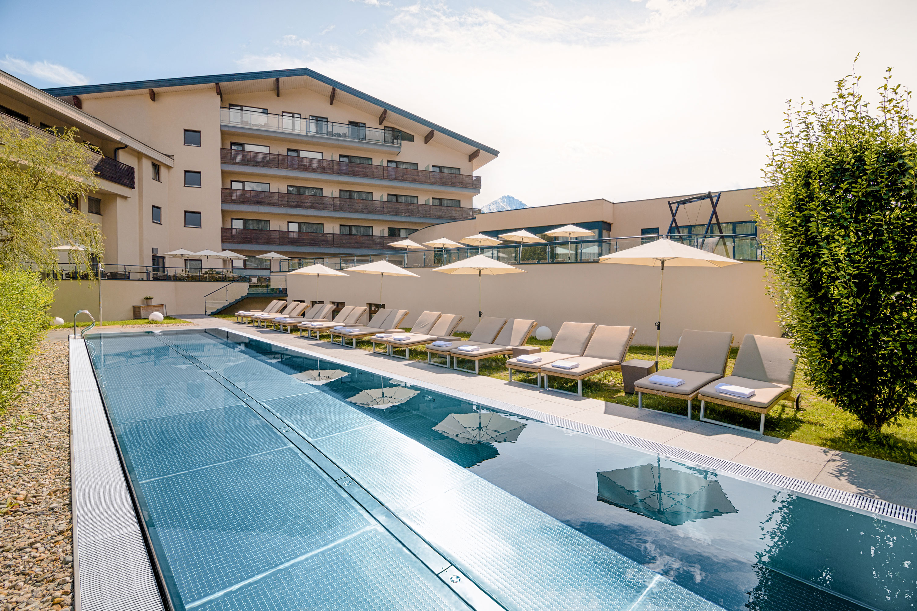 HAIDVOGL MAVIDA Zell am See in Zell am See – Außenpool mit Liegen und Hotelgebäude | Wellnesshotel Salzburger Land