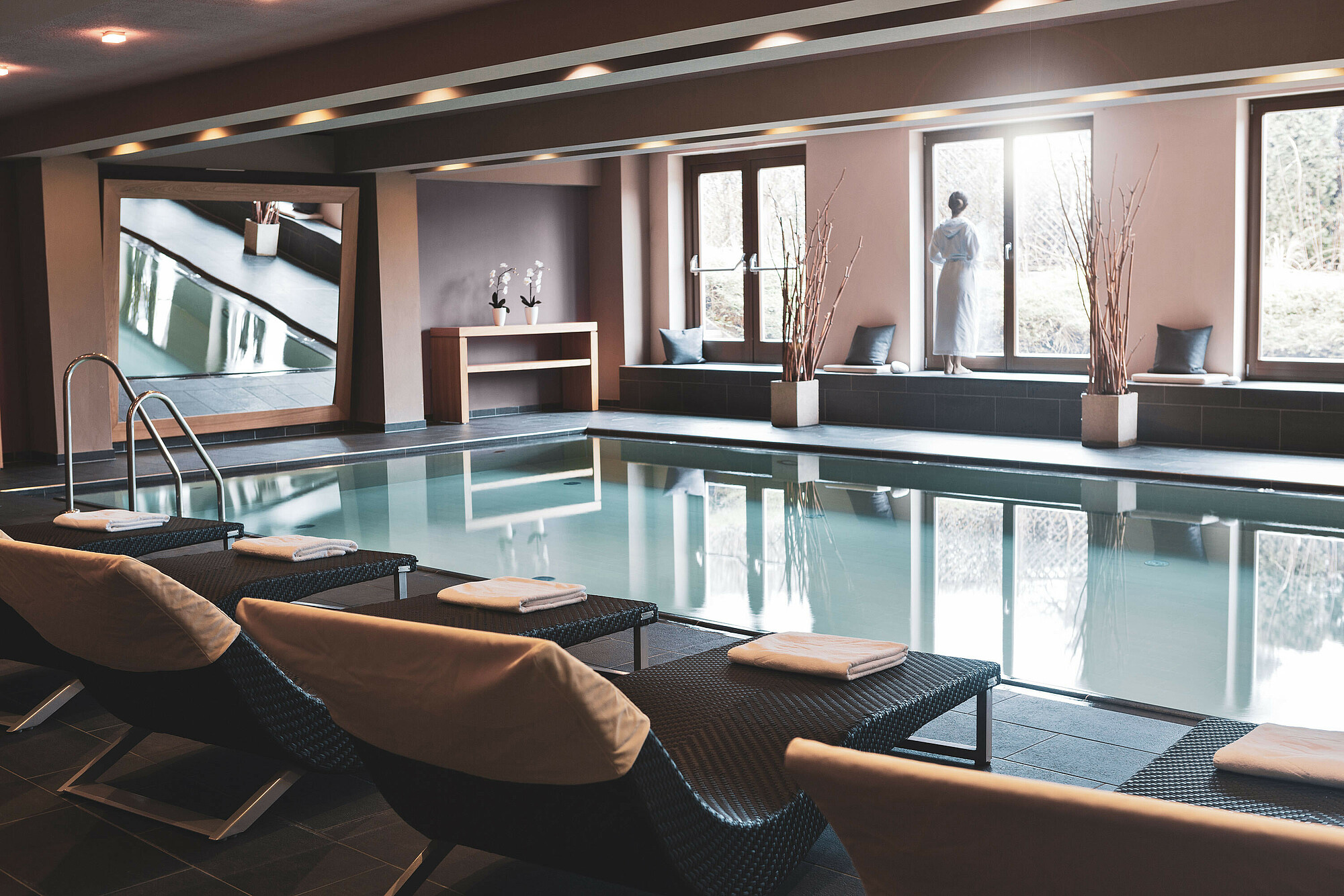 HAIDVOGL MAVIDA Zell am See in Zell am See – Innenpool mit Ruheliegen und Blick ins Grüne | Wellnesshotel Salzburger Land