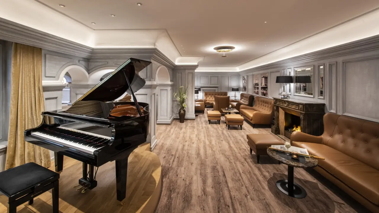 Elegante Hotellobby mit Flügel und Kamin im Parkhotel Bad Füssing, ideal zum Entspannen.