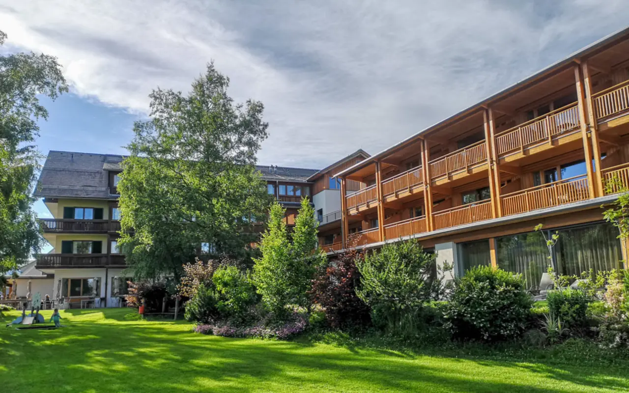 Aussenansicht des Naturhotel Bauernhofer mit traditioneller Holzfassade, Balkonen und weitläufigem grünen Gartenbereich.