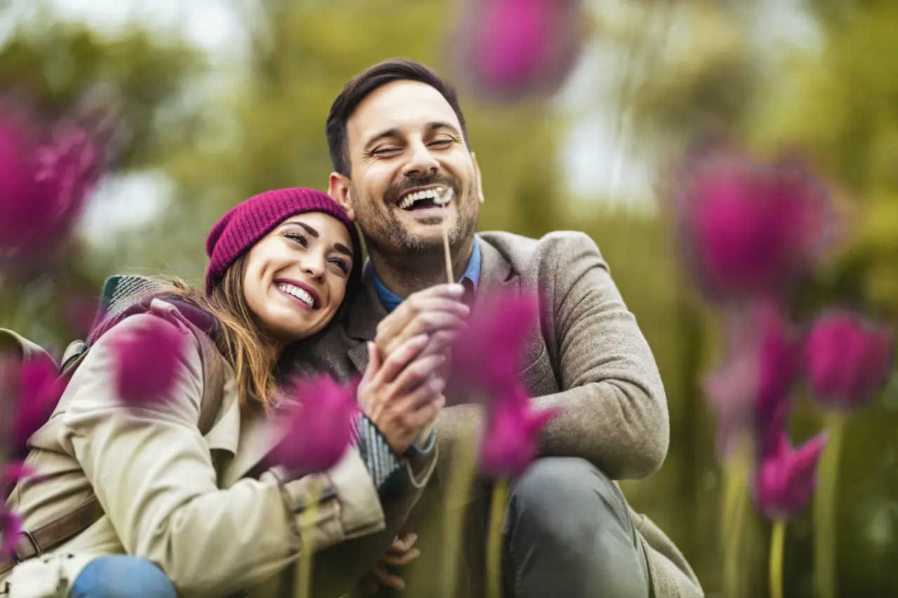 Glückliches Paar lacht und genießt die Natur im Garten des Schwarzwald Panorama Hotels.