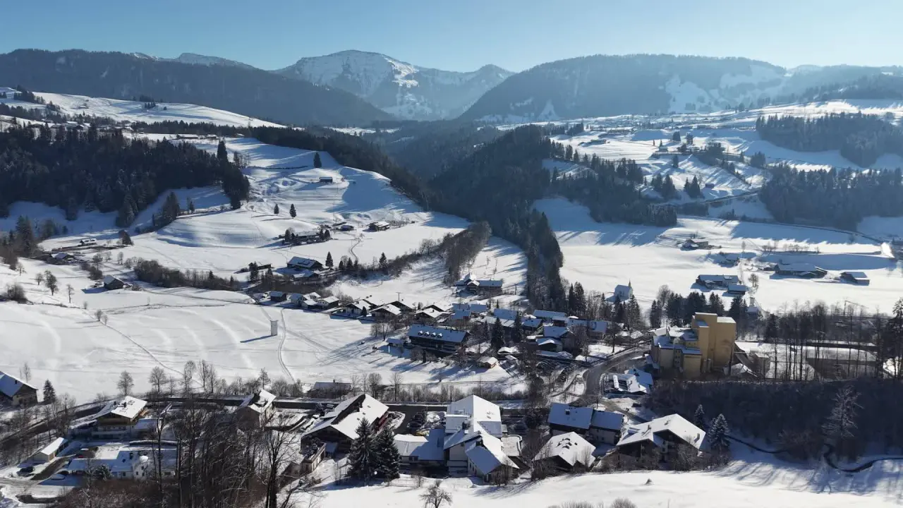 Idyllische Winterlandschaft mit verschneitem Dorf und majestätischen Bergen rund um das Königshof Hotel Resort.