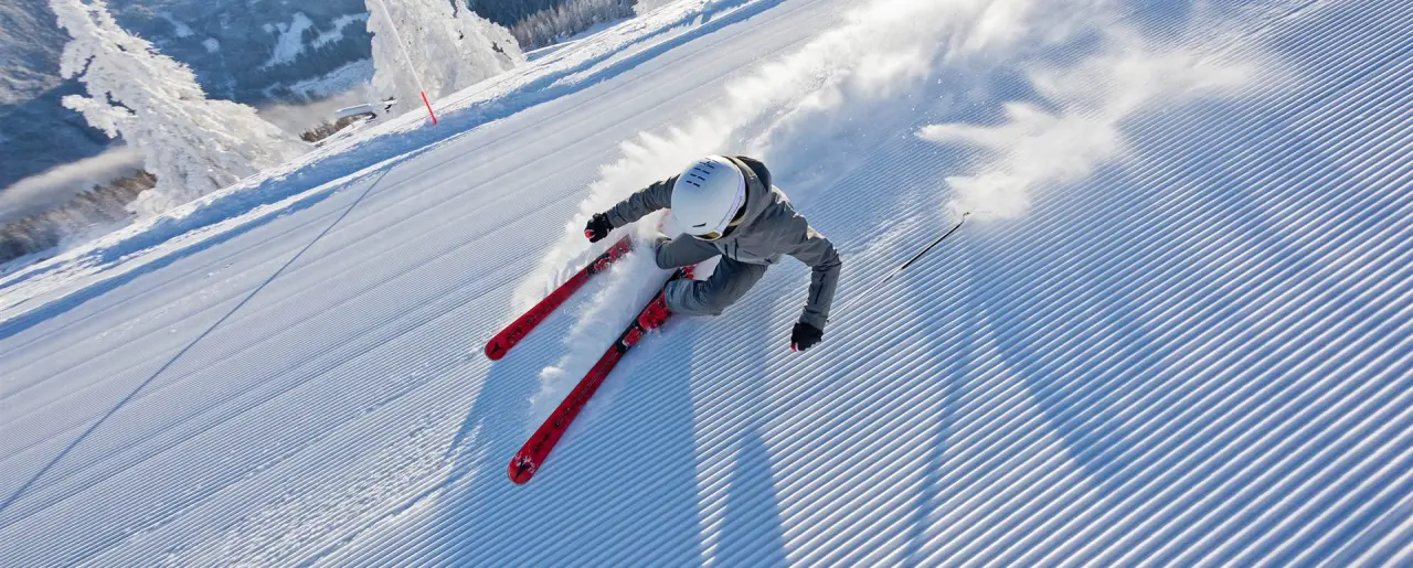 Skifahrer auf frisch präparierter Piste mit Pulverschnee im Skigebiet des Naturhotel Edelweiss.