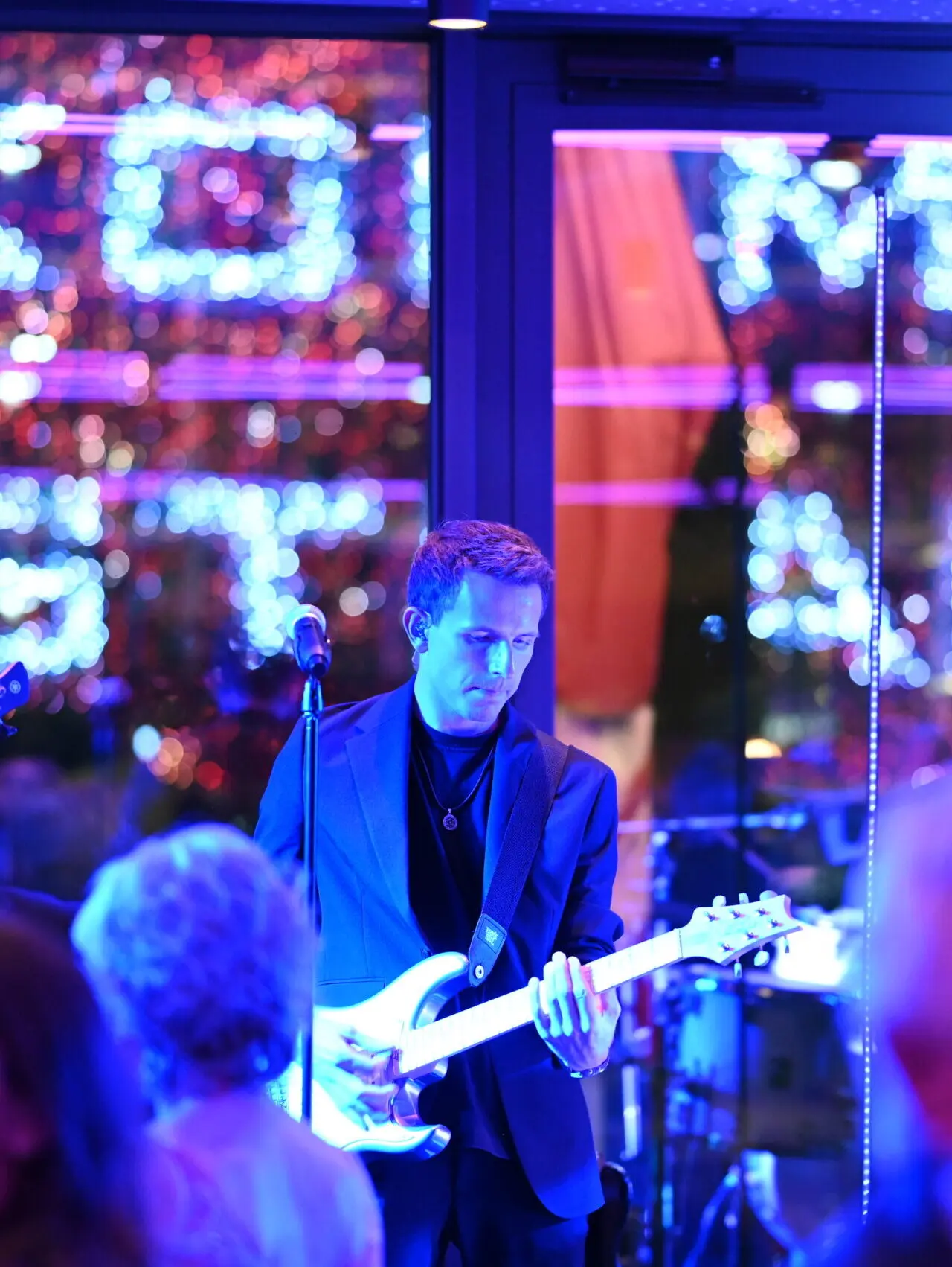 Gitarrist bei Live-Musik-Performance mit blauer Beleuchtung im Meiser Vital Hotel. Abendunterhaltung für Gäste.
