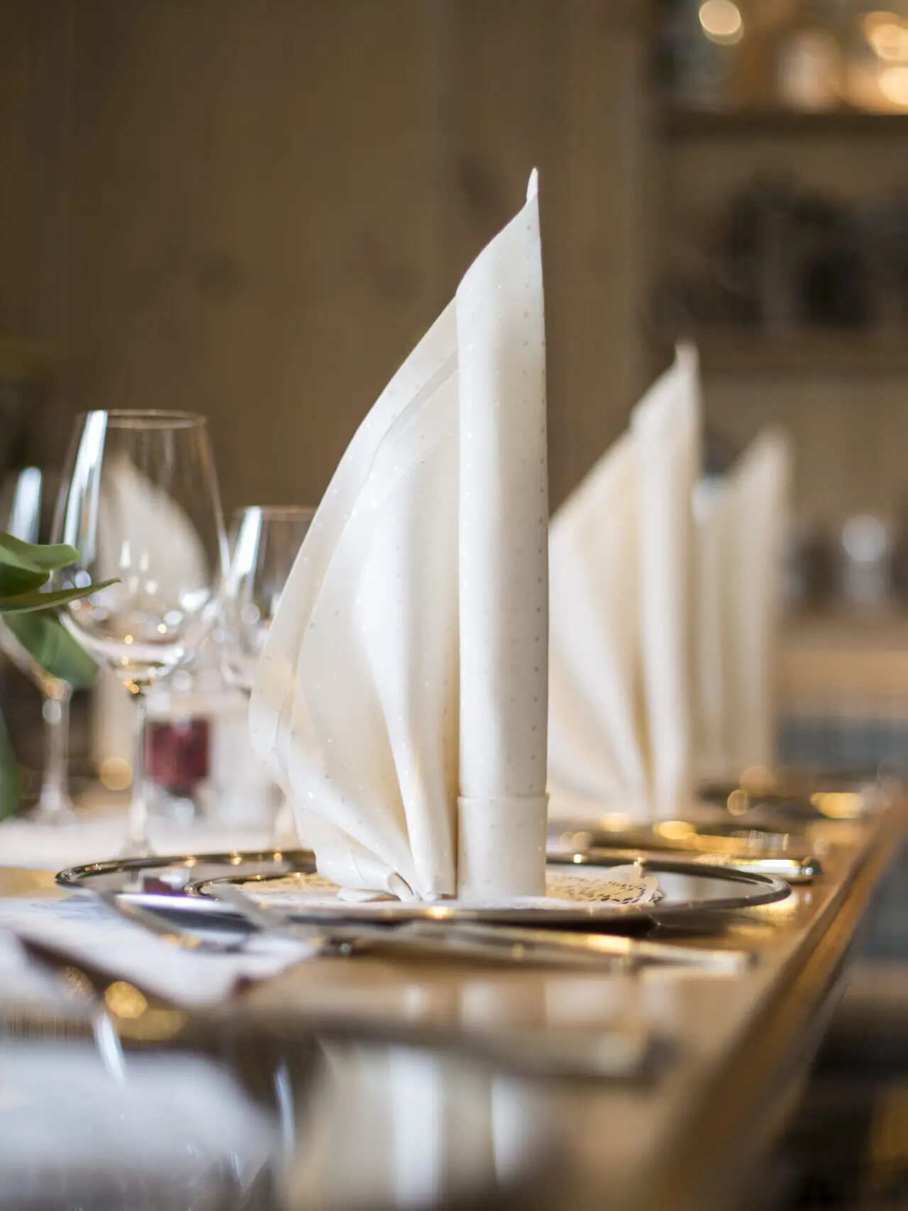 Elegant gedeckter Tisch mit gefalteten Servietten und Weingläsern im Restaurant des Meiser Vital Hotels.