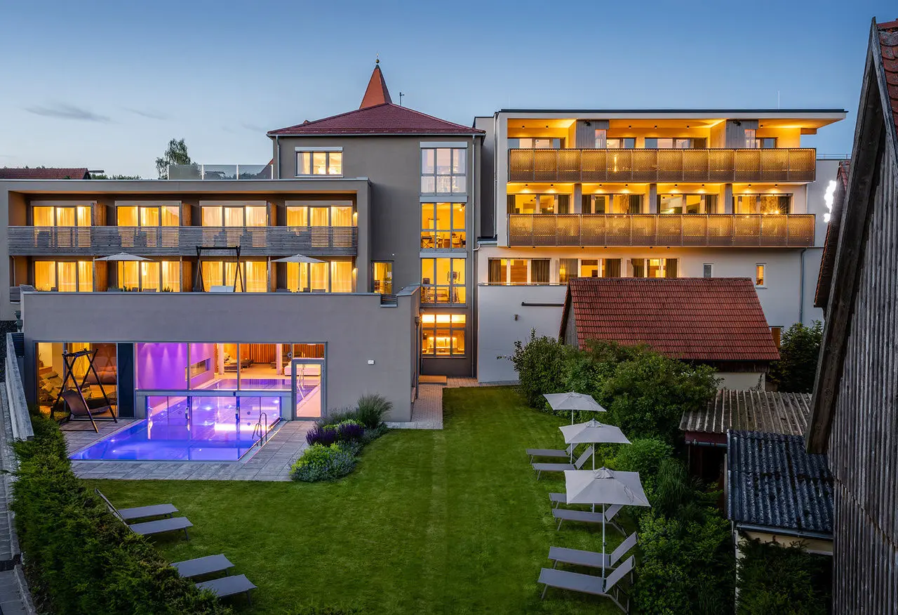 Abendansicht des Landhotel Weißes Ross mit beleuchtetem Aussenbereich, modernem Pool und gemütlichen Balkonen.