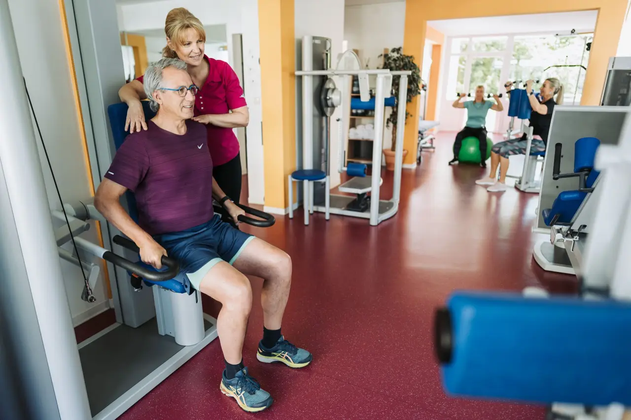 Gäste trainieren im modernen Fitnessbereich des Kurhotel Sonnenhof mit professioneller Betreuung.