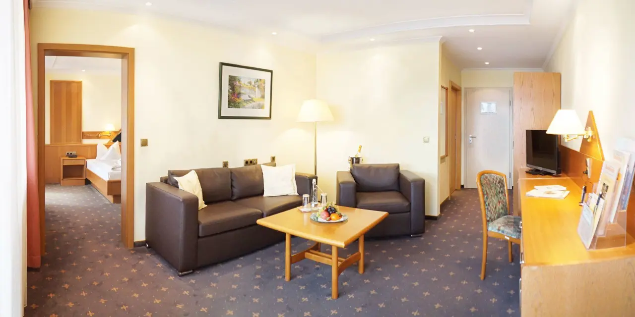 Geräumige Suite mit Wohnbereich und Schlafzimmer im Kurhotel Sonnenhof. Komfortable Einrichtung für entspannten Aufenthalt.