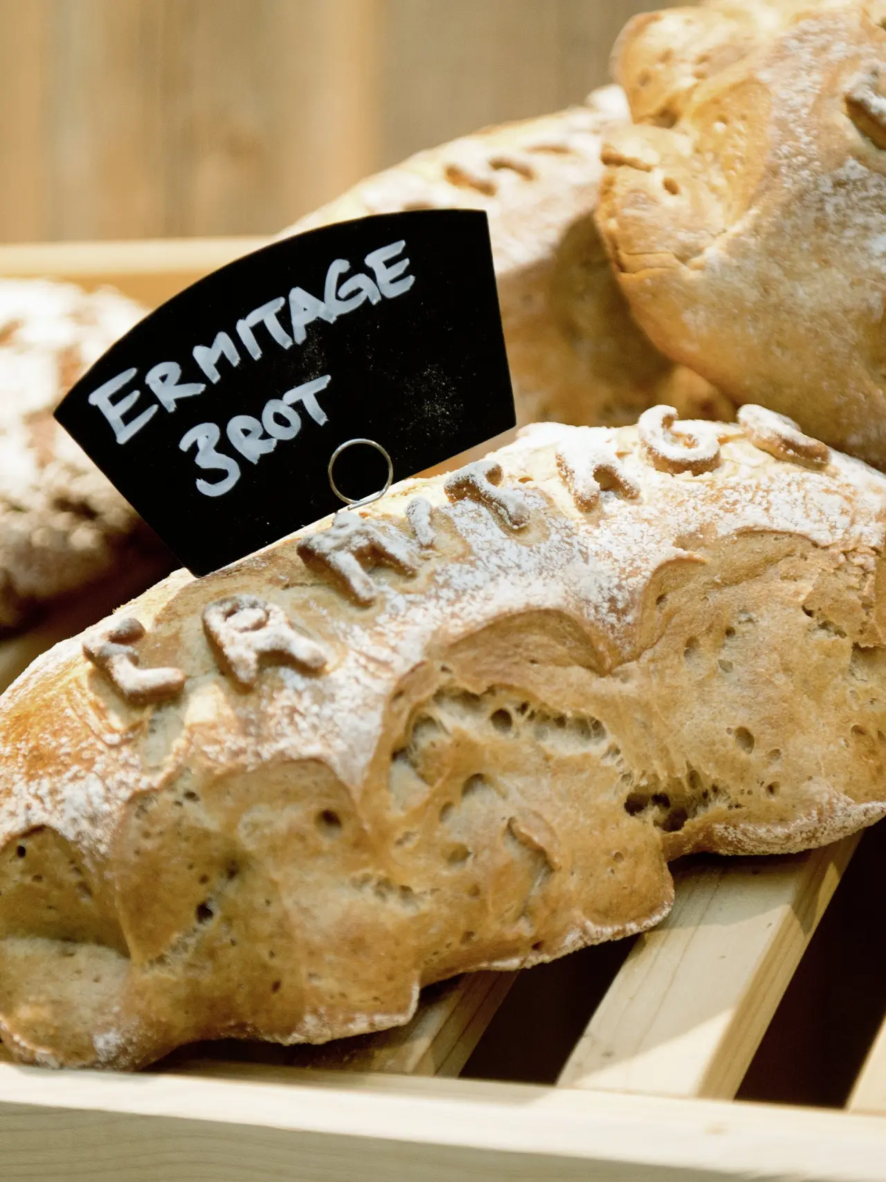 Frisch gebackenes Brot mit dem Namen des ERMITAGE Wellness- & Spa-Hotels, präsentiert im Restaurantbereich.