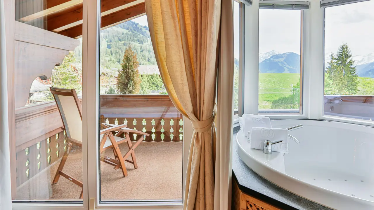 Whirlpool-Badewanne im Hotelzimmer mit Bergblick und Balkon im ERMITAGE Wellness- & Spa-Hotel.