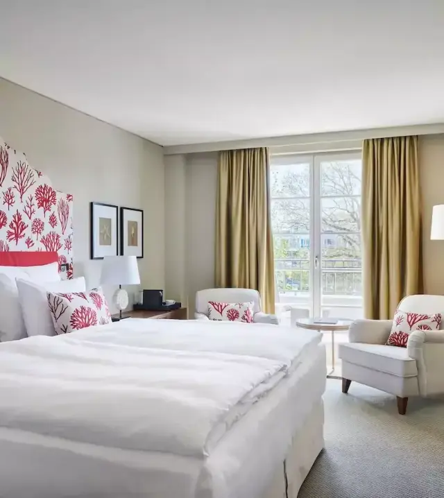 Modernes Doppelzimmer mit Korallen-Design, bequemen Betten und Balkon im Strandhotel Zingst.