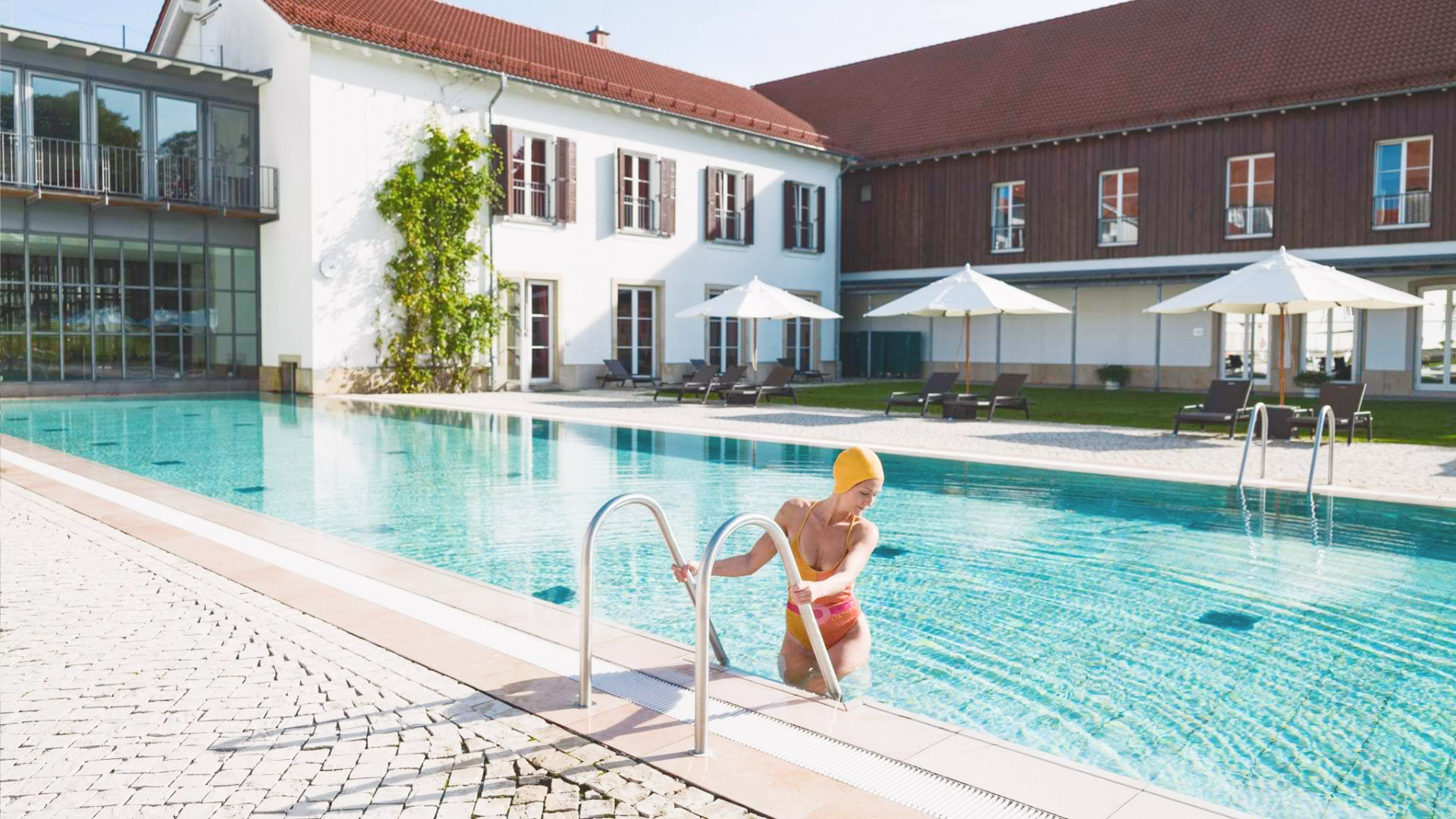 Gräflicher Park Health & Balance Resort in Bad Driburg – Außenpool mit Gast und historischer Architektur | Wellnesshotel Teutoburger Wald