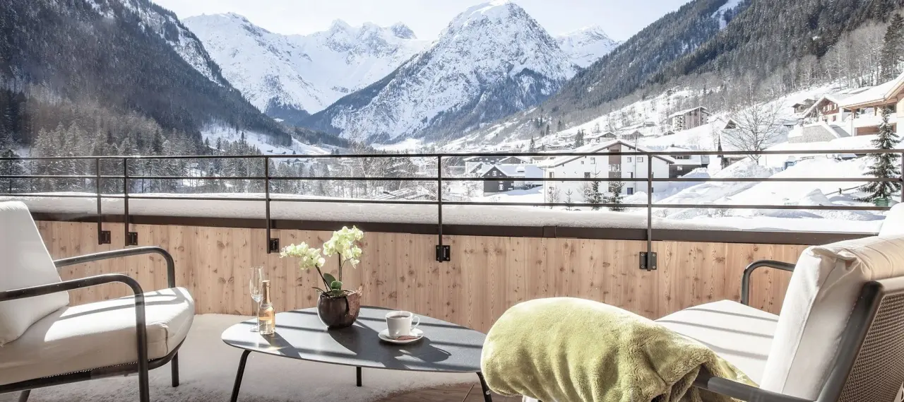 Balkon eines Hotelzimmers im Alpenhotel Zimba mit atemberaubendem Blick auf die verschneiten Berge und das Tal.