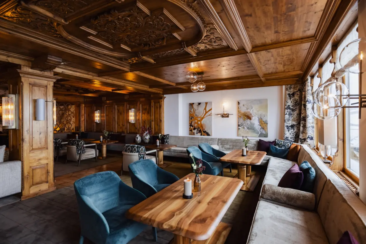 Gemütliche Lounge im alpinen Stil mit Holzschnitzereien und bequemen Sitzgelegenheiten im Hotel Zürserhof.