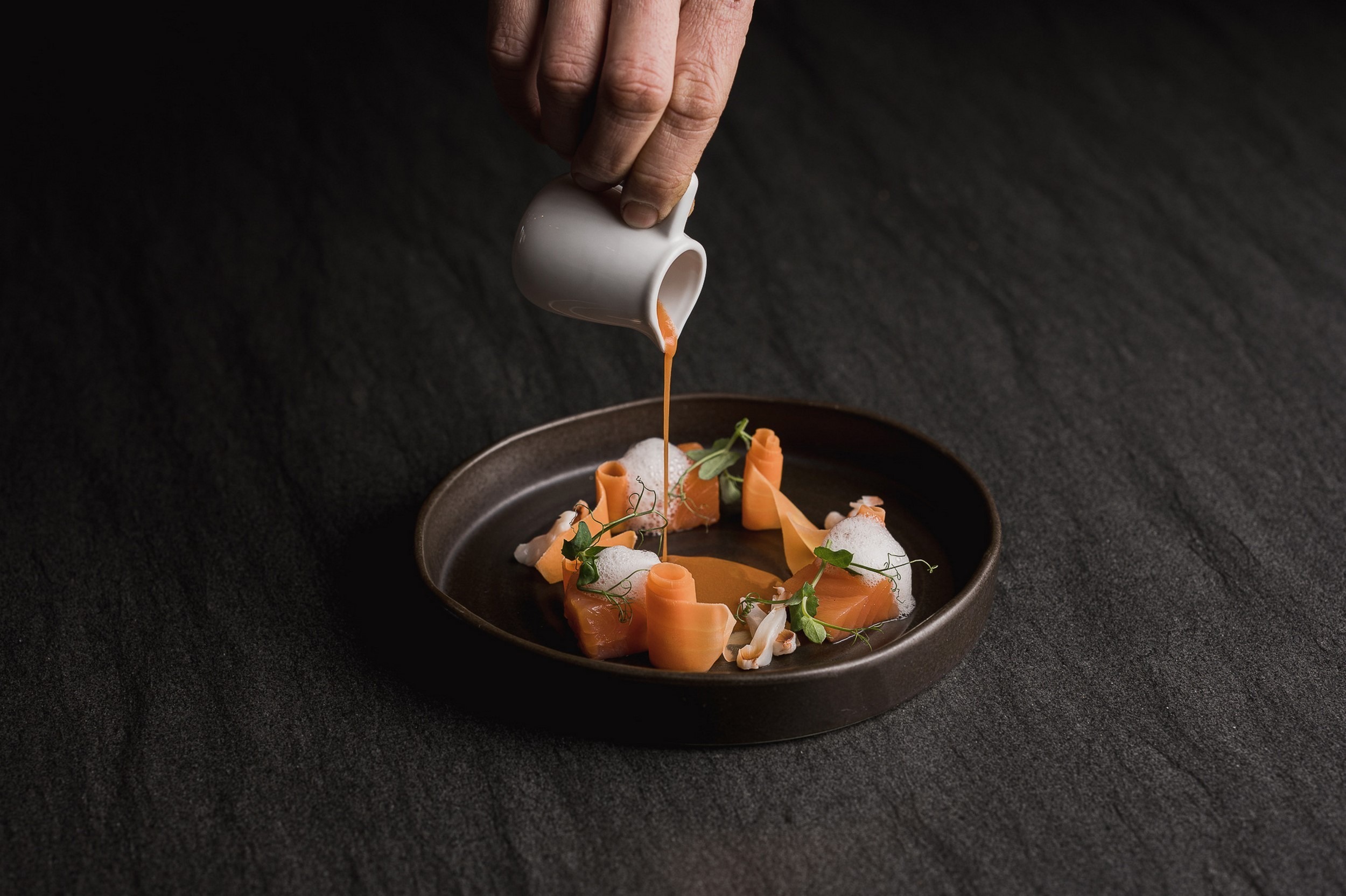 La Maiena Meran Resort in Marling – Gourmetgericht mit Sauce auf dunklem Teller | Wellnesshotel Südtirol