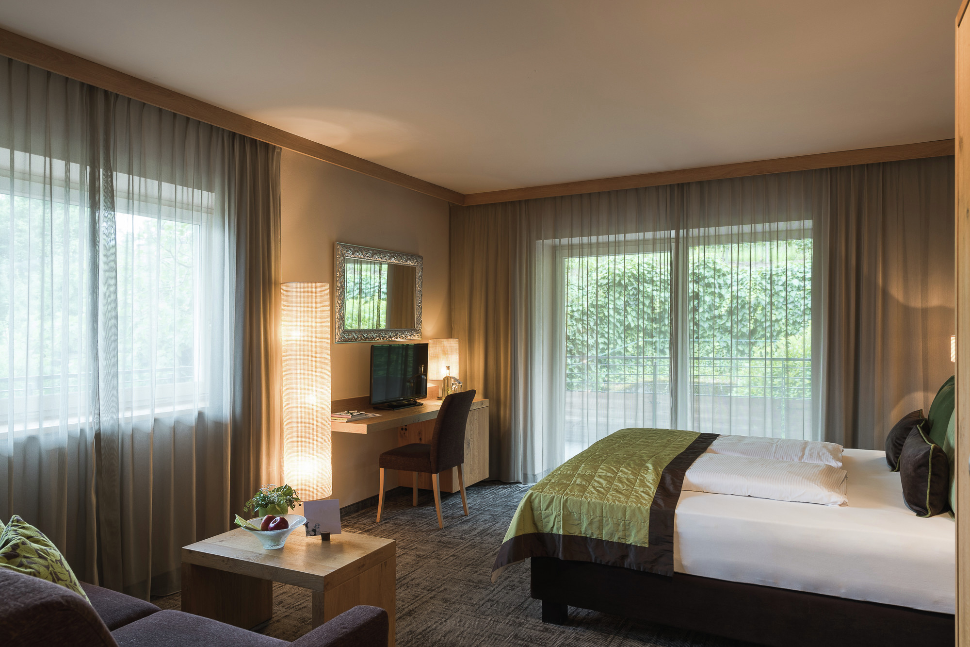 La Maiena Meran Resort in Marling – Helles Hotelzimmer mit Doppelbett und Blick ins Grüne | Wellnesshotel Südtirol