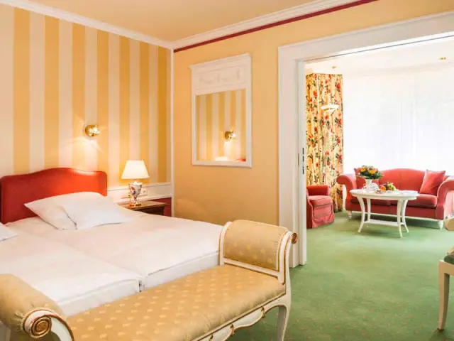 Geräumiges Hotelzimmer mit Doppelbett und separatem Wohnbereich im Relais & Châteaux Hotel Schwarzmatt.