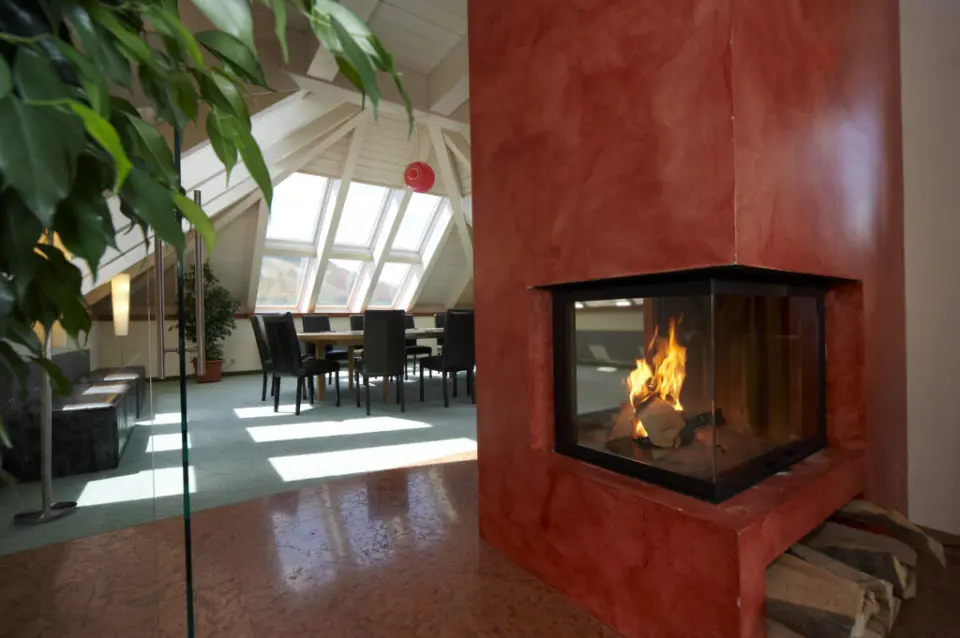 Gemütlicher Lounge-Bereich mit Kamin und Dachfenstern im Hotel Eden