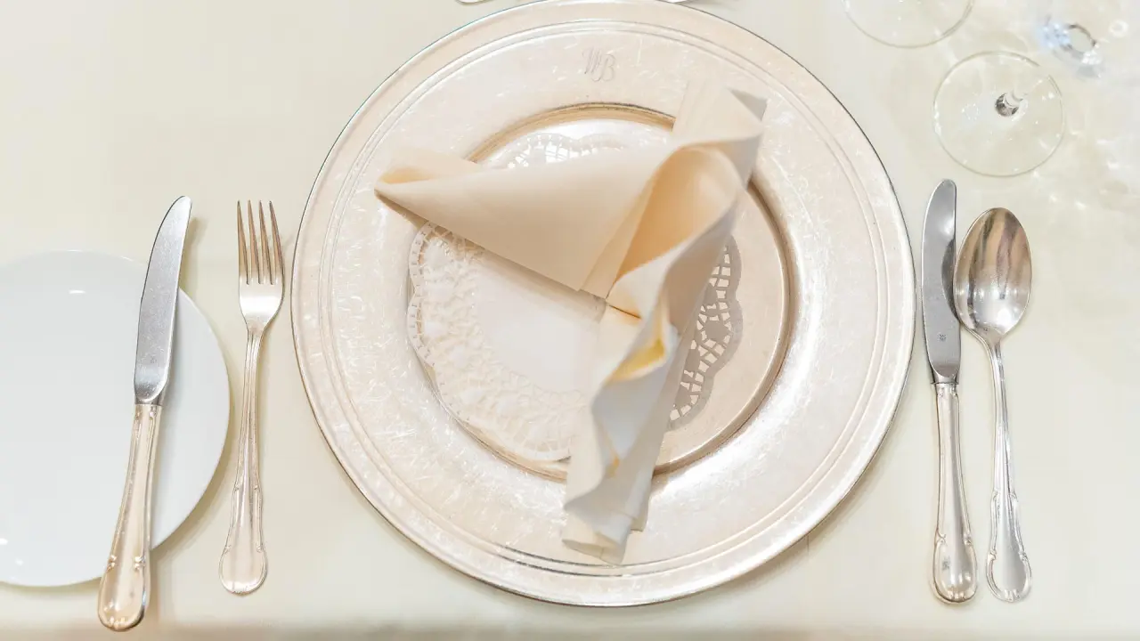 Elegante Tischdekoration mit Besteck, Teller und Stoffserviette im Restaurant des Romantik Hotel Bösehof.