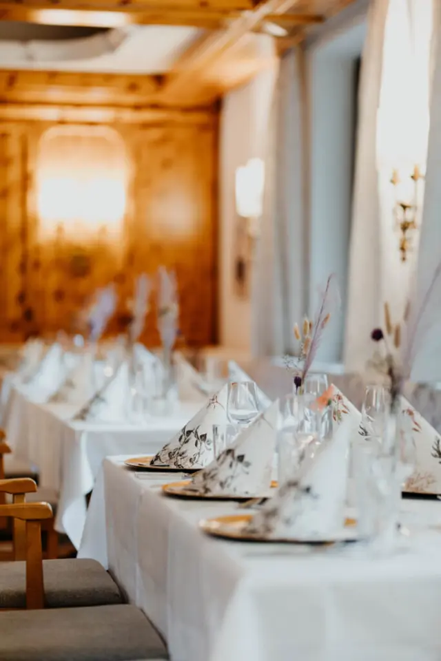 Elegant gedeckter Tisch im Restaurant des sonnenhotel ZUM STERN mit Holzvertäfelung und warmem Licht.