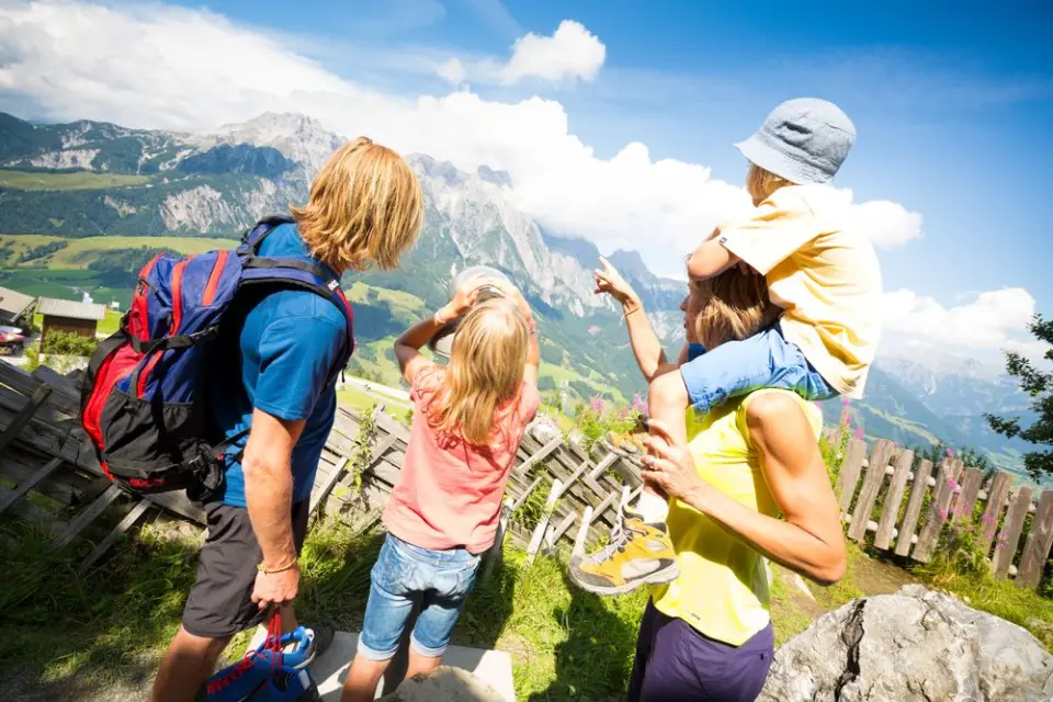 Familie mit Kindern beim Wandern in den Alpen. Panoramablick auf die Bergwelt rund um das Hotel Schörhof im Salzburger Land.