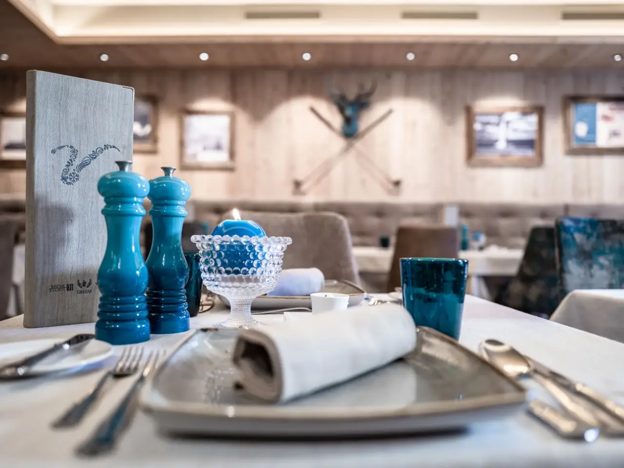 Elegant gedeckter Tisch mit blauen Akzenten im Restaurant des Hotel Vier Jahreszeiten.