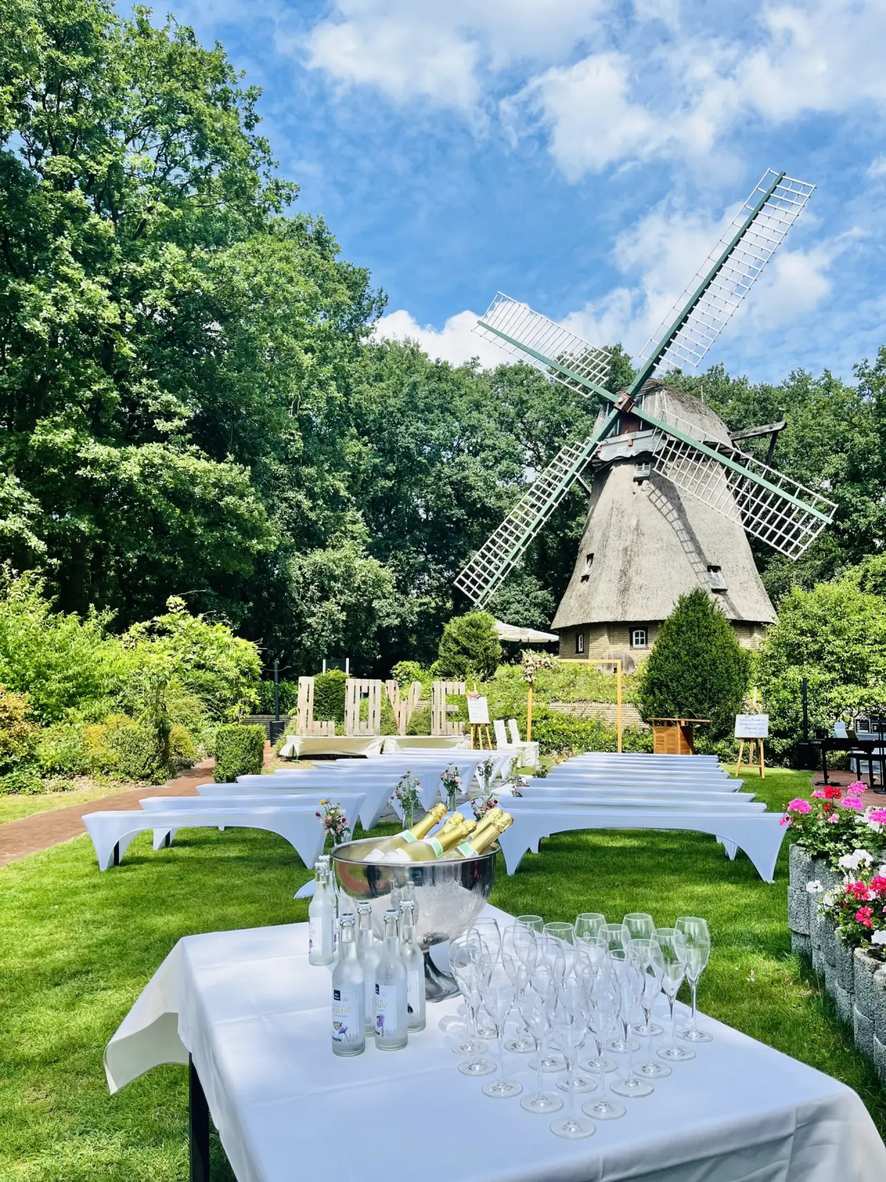 Festlich dekorierter Gartenbereich mit historischer Windmühle und Sektbar für Veranstaltungen im Romantik Hotel Aselager Mühle.