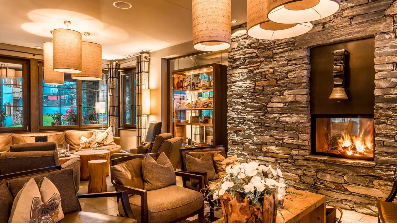 Gemütliche Hotellounge mit Kamin und bequemen Sesseln im La Val Hotel & Spa. Warme Atmosphäre für entspannte Abende.