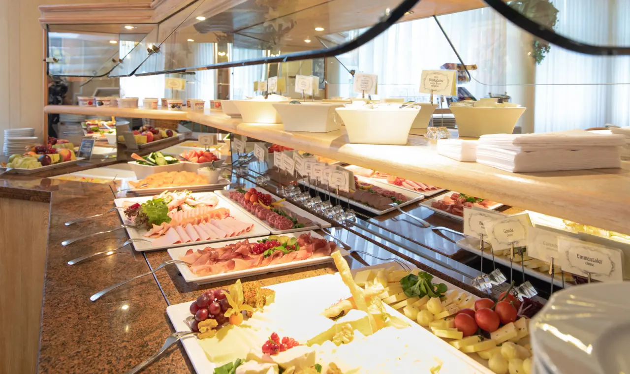 Reichhaltiges Frühstücksbuffet mit Käse, Wurst, Obst und Joghurt im Restaurant des Hotel Flora.
