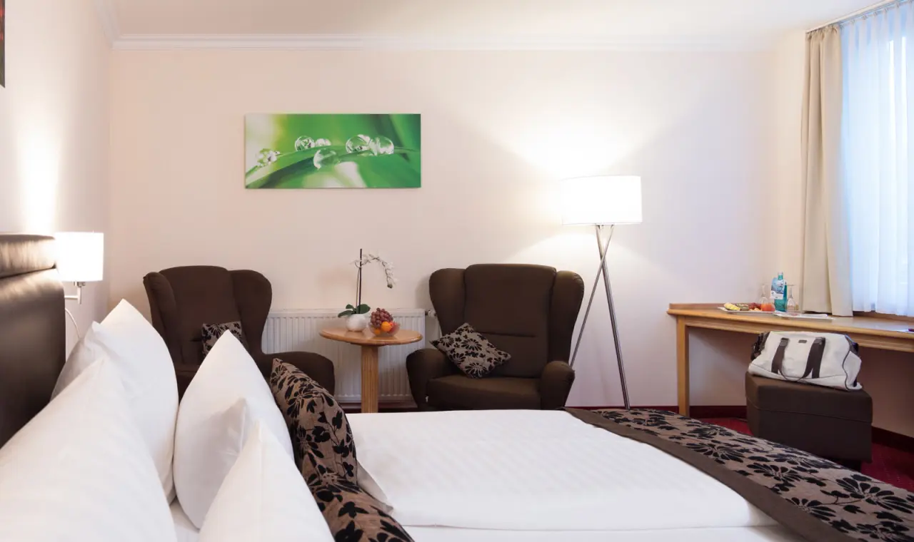 Hotel Flora: Komfortables Doppelzimmer mit Sitzbereich, Schreibtisch und modernem Dekor.