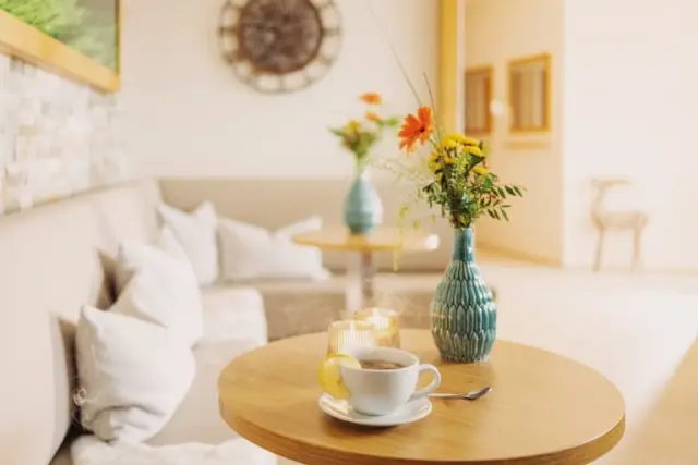 Gemütliche Sitzecke mit Teetasse, frischen Blumen und Kerzen im Hotel Larimar. Ideal zum Entspannen.