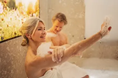 Glückliches Paar genießt ein entspannendes Schaumbad im Hamam-Bereich des Hotel Larimar. Wellness-Erlebnis.