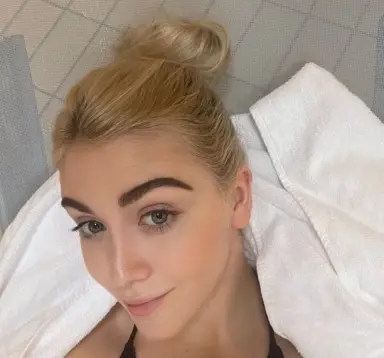 Junge Frau entspannt im weißen Handtuch nach einem Wellness-Besuch im Avita Resort.