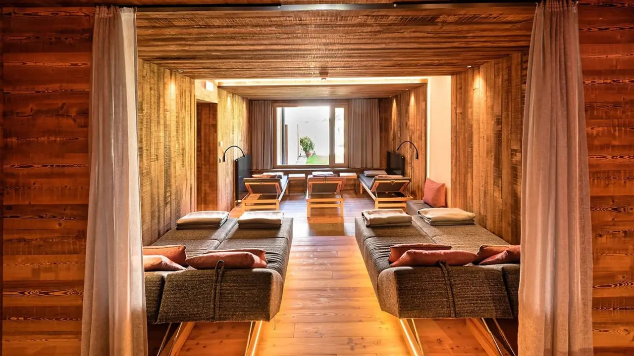 Entspannungsraum mit Holzvertäfelung und bequemen Liegen im Spa des Holzleiten Bio Wellness Hotels.