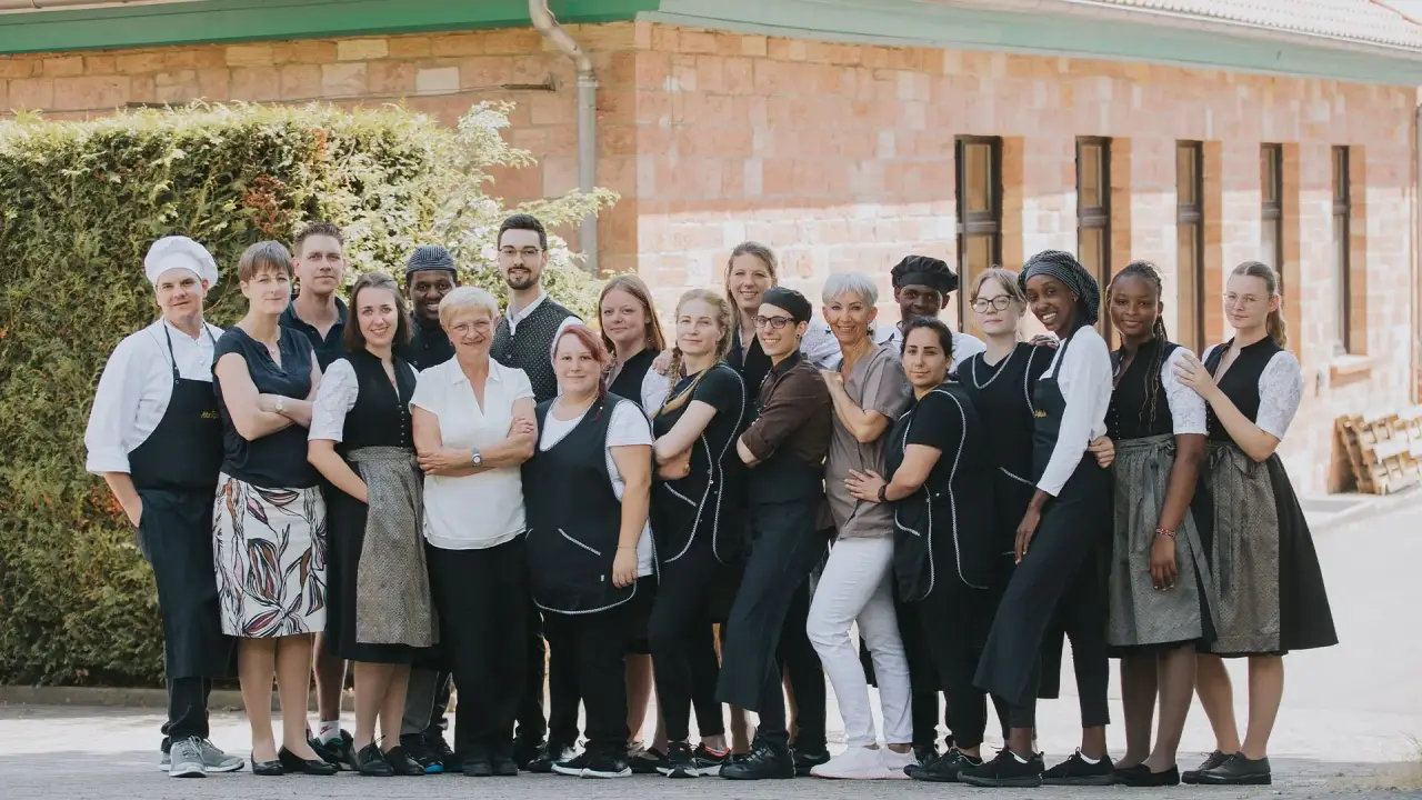 Freundliches Team des Wohlfühlhotel Alte Rebschule vor dem Hotelgebäude. Engagierte Mitarbeiter für Ihren Wellnessurlaub.