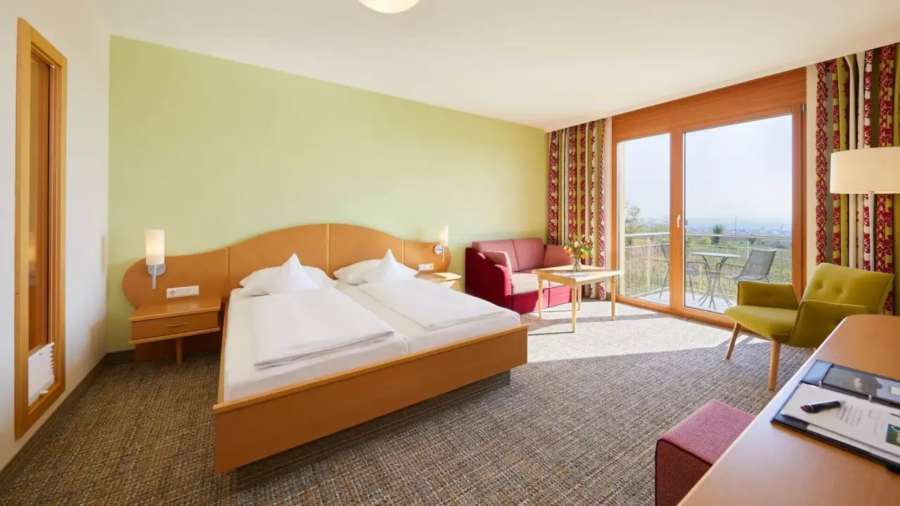 Helles Doppelzimmer mit Balkon und Sitzbereich im Wohlfühlhotel Alte Rebschule, ideal für entspannte Aufenthalte.