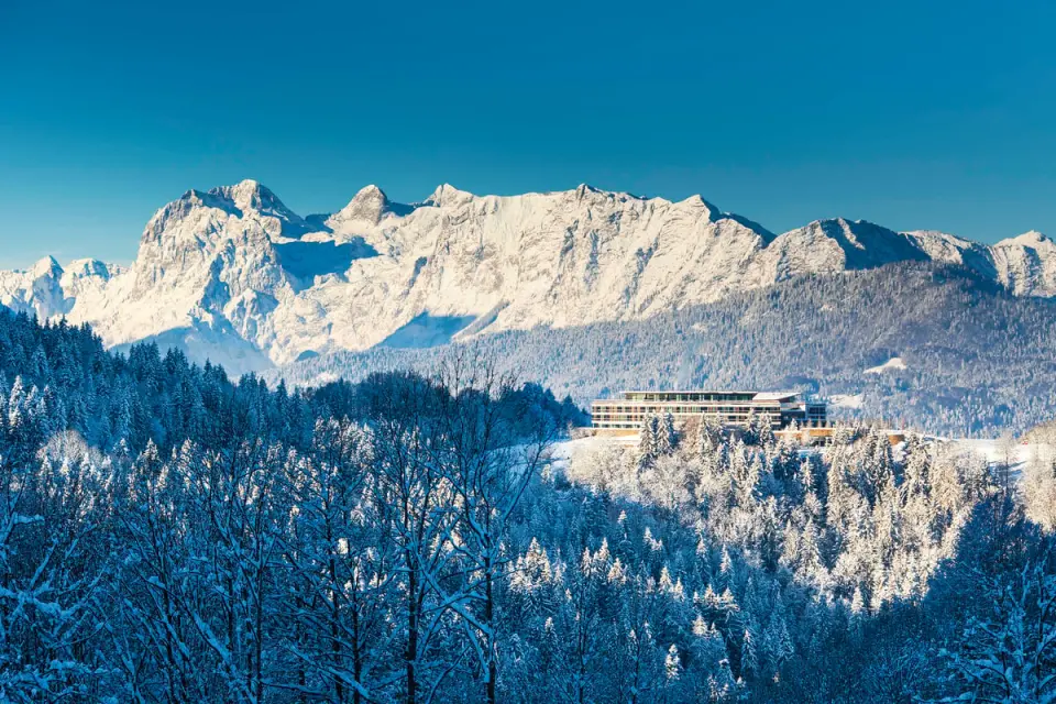 Kempinski Hotel Berchtesgaden im Winter: Luxushotel inmitten verschneiter Alpenlandschaft mit majestätischem Bergpanorama.