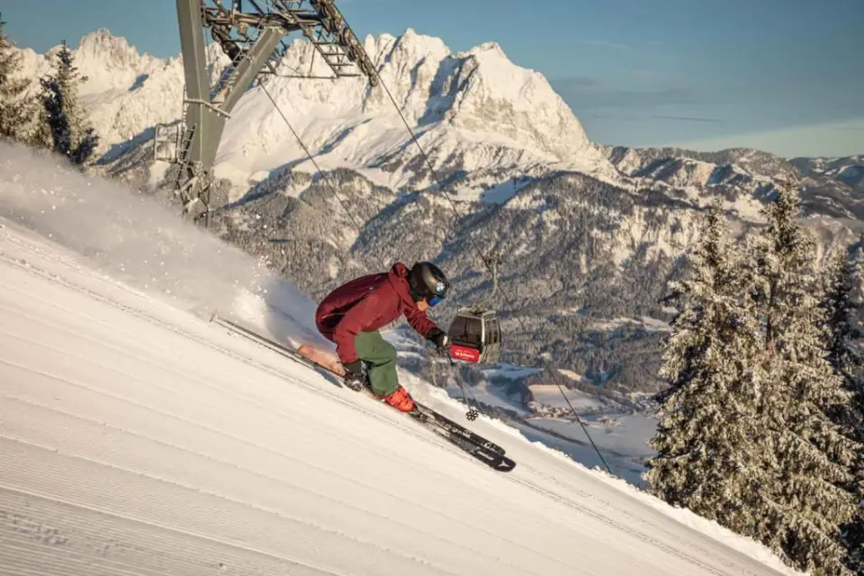 Skifahrer auf frisch präparierter Piste mit Bergpanorama und Gondelbahn im Skigebiet des Hotel Penzinghof.