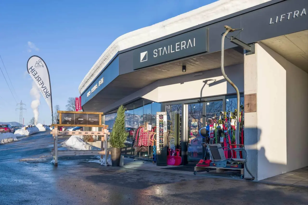 Aussenansicht des Skiverleihs Stailerai mit Wintersportausrüstung und Skilift-Sitz im Winter, nahe Hotel Penzinghof.