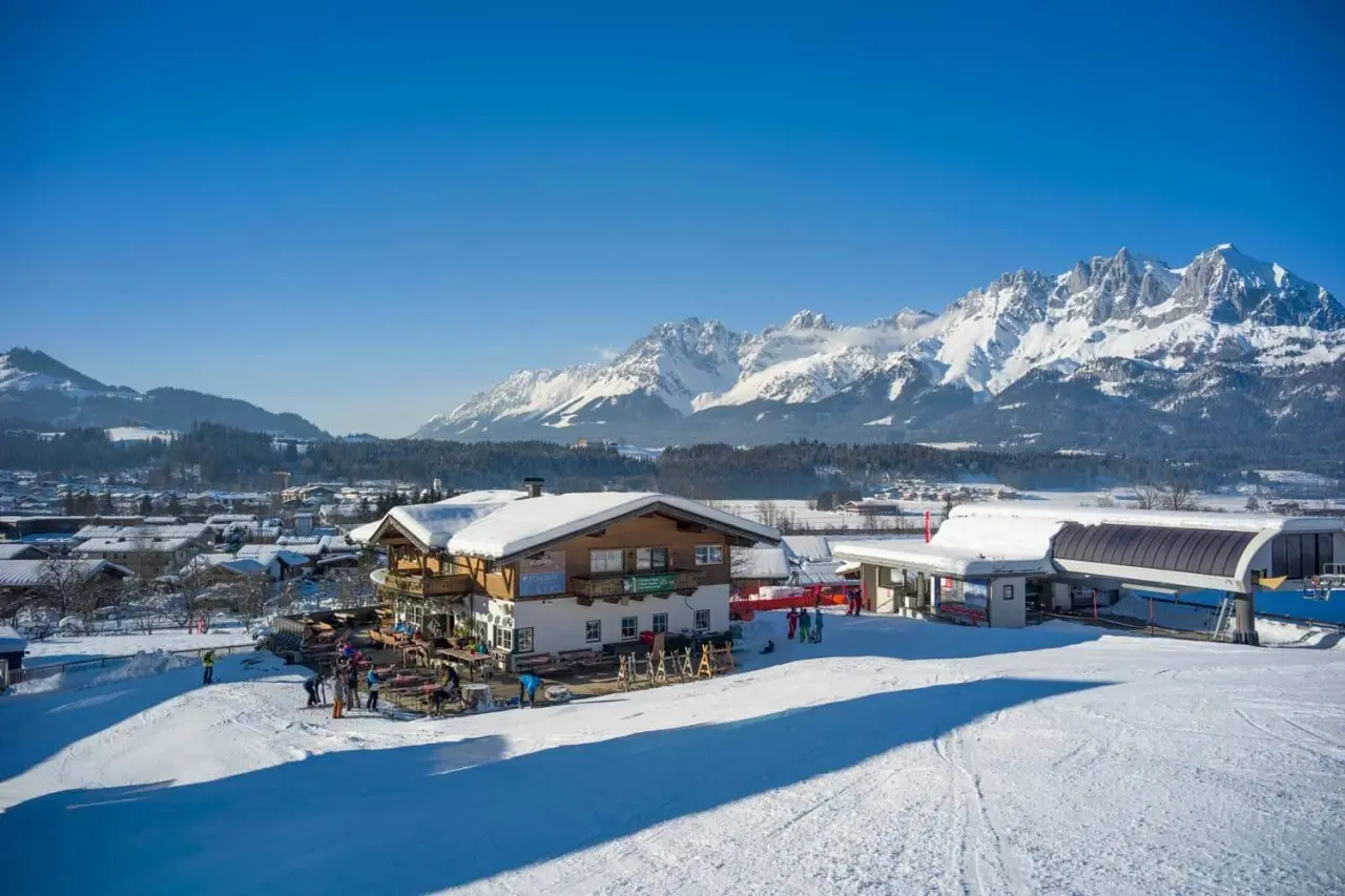 Winterlandschaft mit Hotel Penzinghof direkt an der Skipiste und majestätischem Bergpanorama.