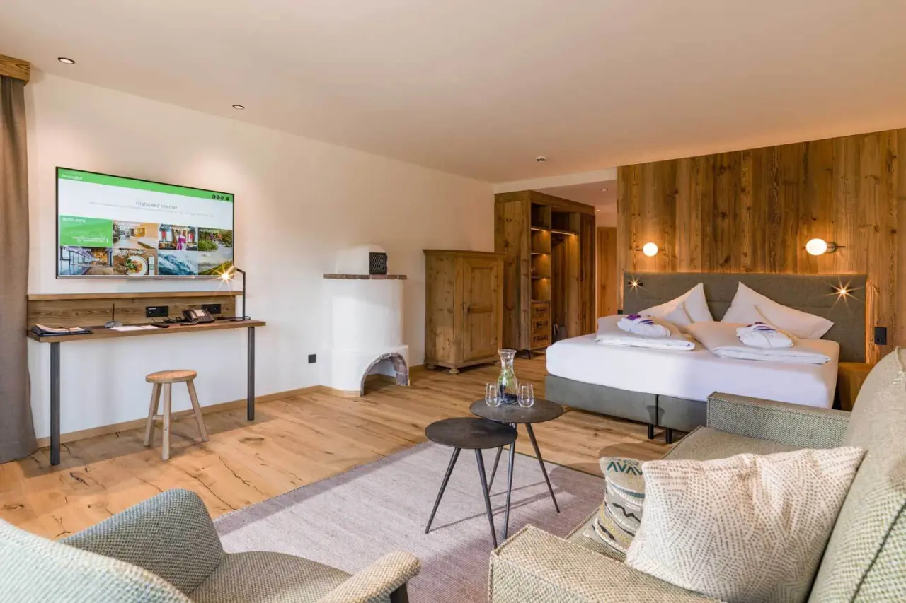 Gemütliches Doppelzimmer im alpinen Stil mit Holzelementen, Kaminofen und TV im Hotel Penzinghof.